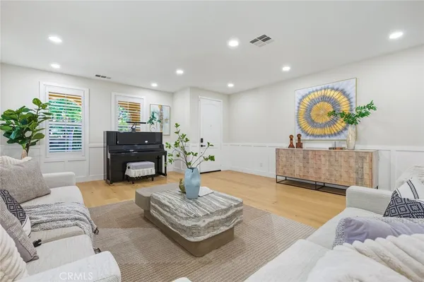 a living room with furniture and a wooden floor