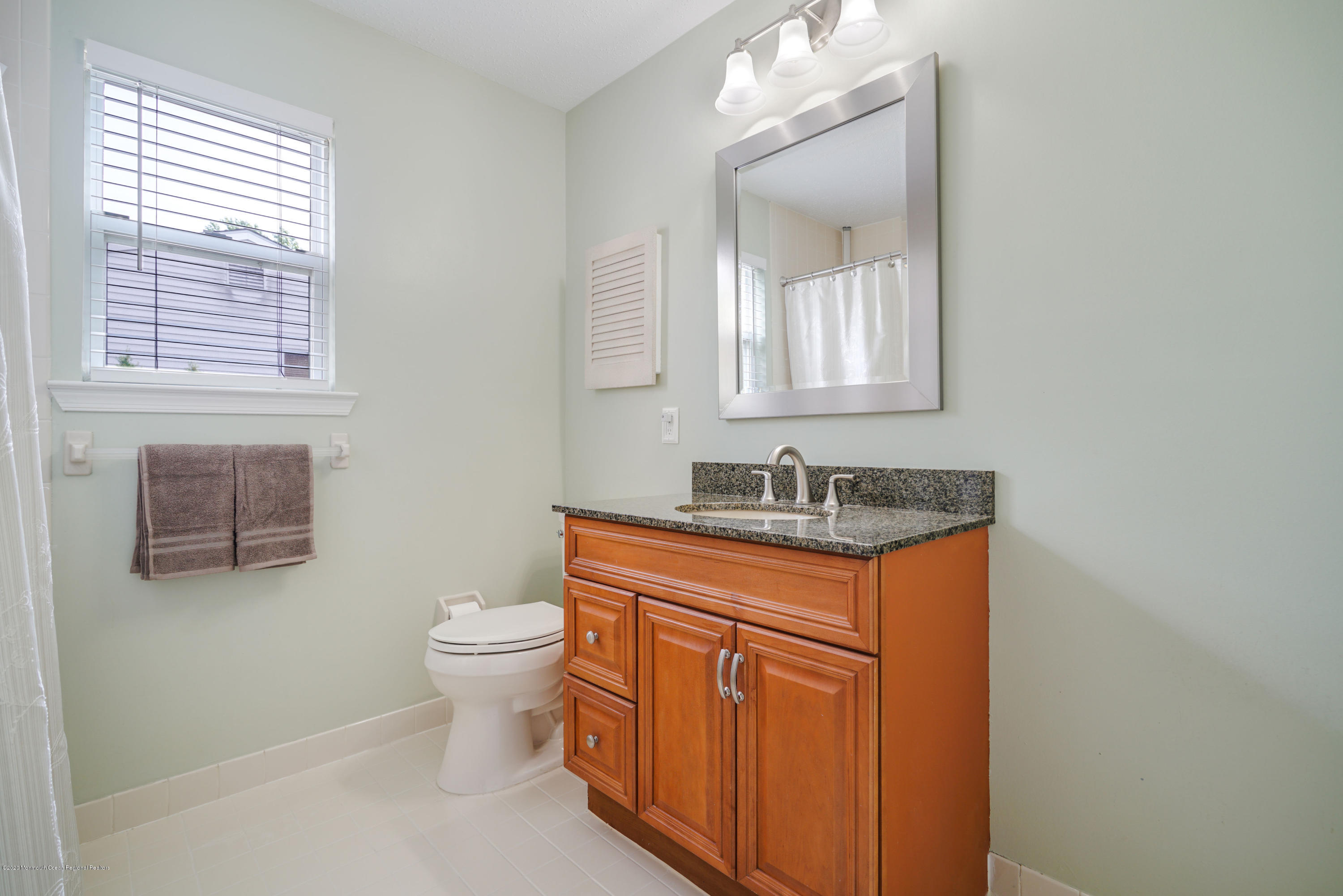 689 Line Road Matawan, NJ 07747 - Photo 17 of 25 a bathroom with a granite countertop sink a toilet and a mirror