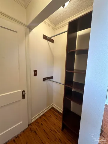 a view of walk in closet with wooden floor