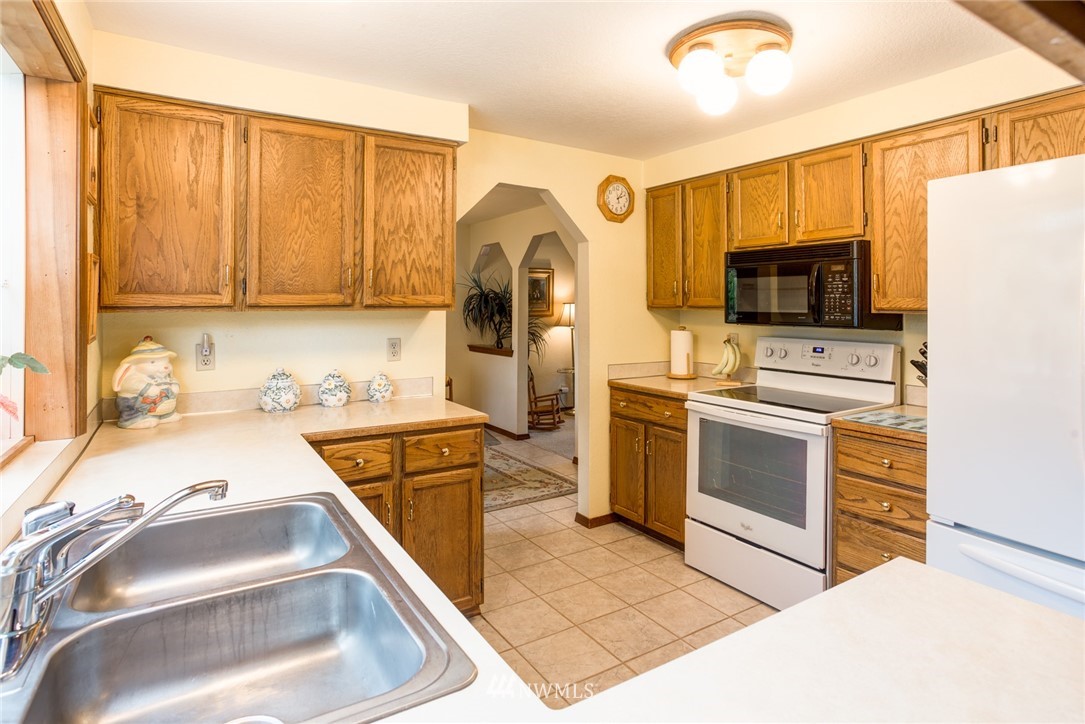2525 166th Place Southeast Bothell, WA 98012 - Photo 7 of 25 a kitchen with a sink a stove and a refrigerator