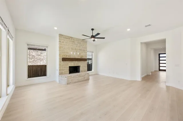 an empty room with windows and fireplace