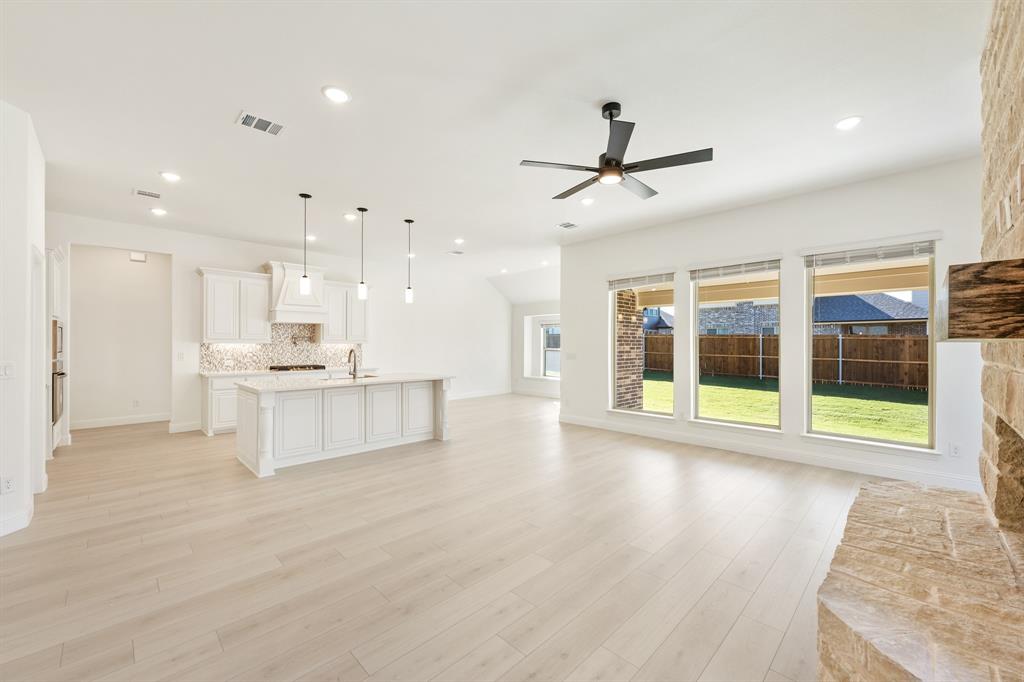 2005 Ambergate Drive Anna, TX 75409 - Photo 15 of 35 a view of an empty room with wooden floor and a kitchen