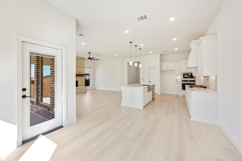2005 Ambergate Drive Anna, TX 75409 - Photo 21 of 35 a view of a kitchen with kitchen island granite countertop wooden floor and a refrigerator