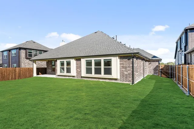 a front view of a house with a yard and trees