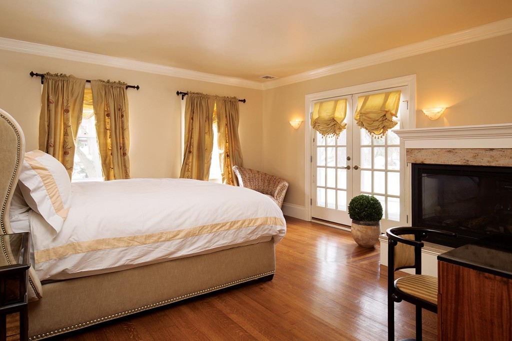 95 Clinton Road Brookline, MA 02445 - Photo 12 of 19 a bedroom with a bed a fireplace and a large window