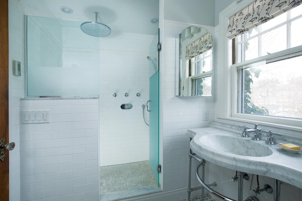 95 Clinton Road Brookline, MA 02445 - Photo 13 of 19 a bathroom with a granite countertop sink a mirror and a shower