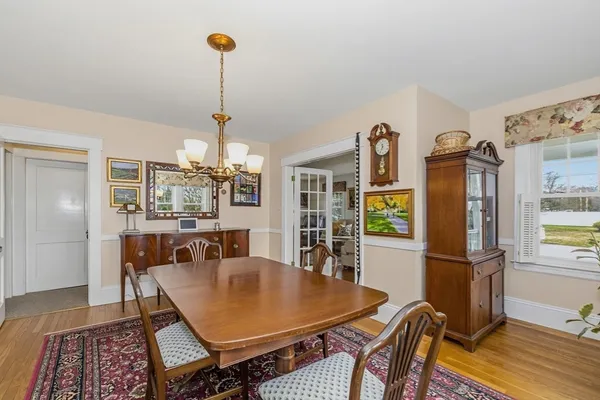 a dining room with furniture a chandelier and wooden floor