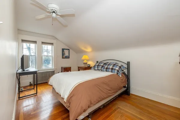 a bedroom with a bed and wooden floor