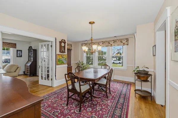 a dining room with furniture a rug a potted plant and a chandelier