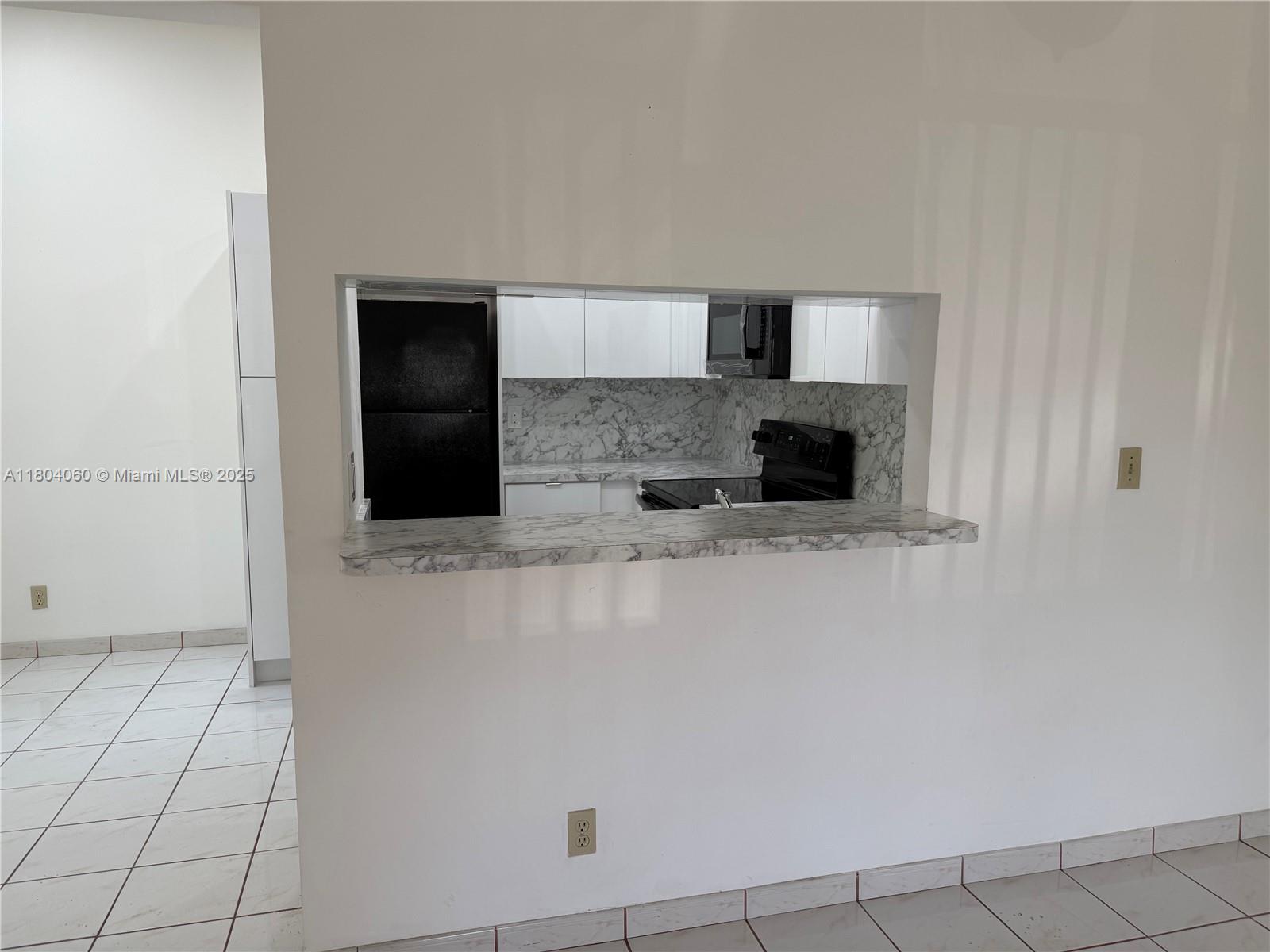 10631 Northwest 14th Street, Unit 229 Plantation, FL 33322 - Photo 3 of 12 a kitchen with granite countertop white cabinets and stainless steel appliances