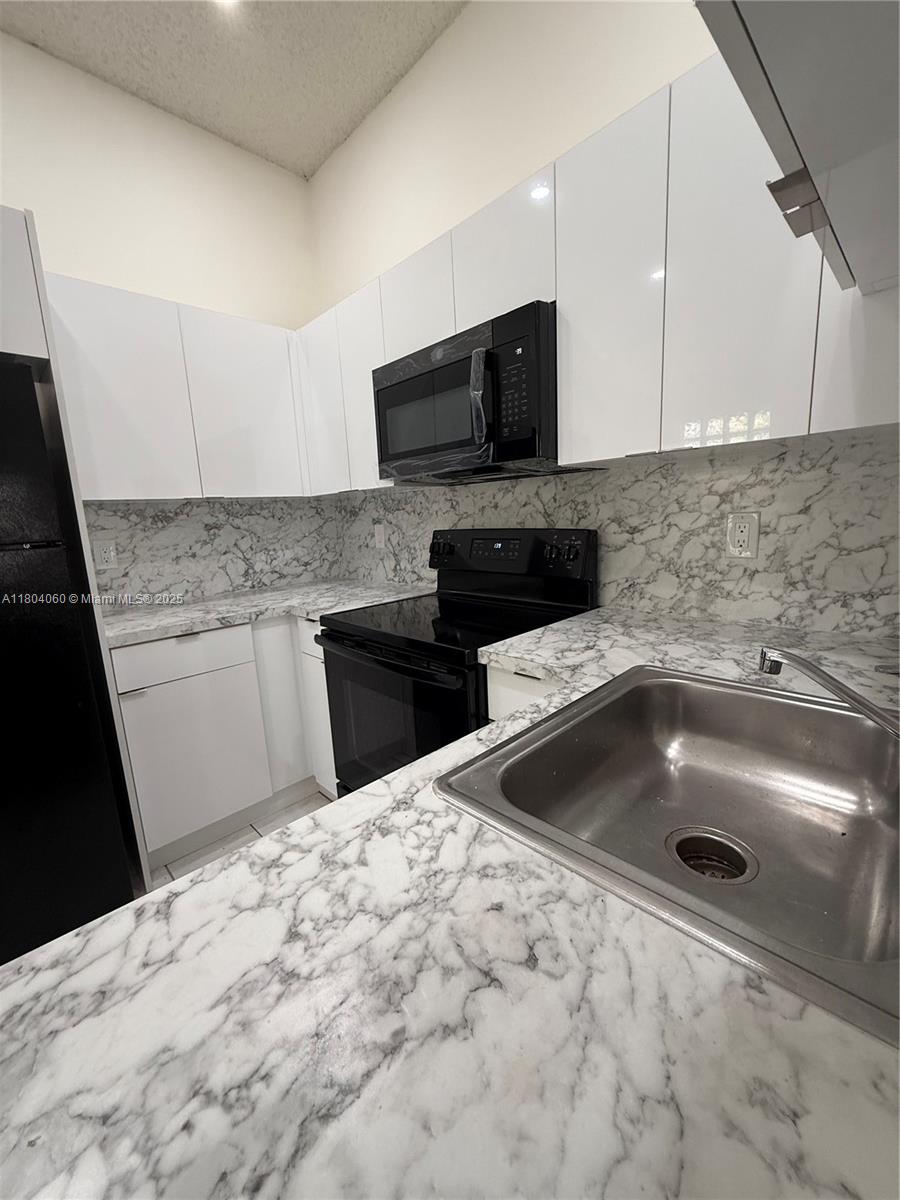 10631 Northwest 14th Street, Unit 229 Plantation, FL 33322 - Photo 6 of 12 a kitchen with a sink and cabinets