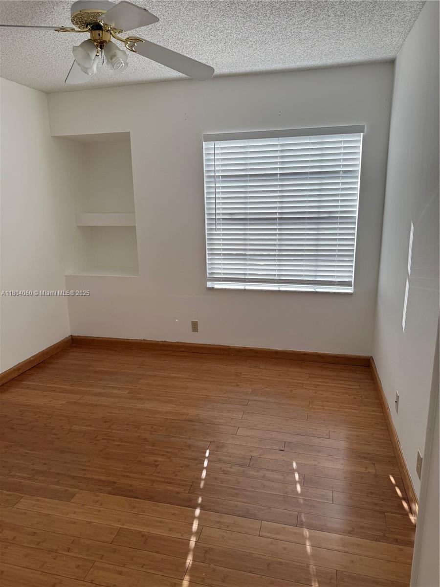 10631 Northwest 14th Street, Unit 229 Plantation, FL 33322 - Photo 7 of 12 a view of an empty room with a window and wooden floor
