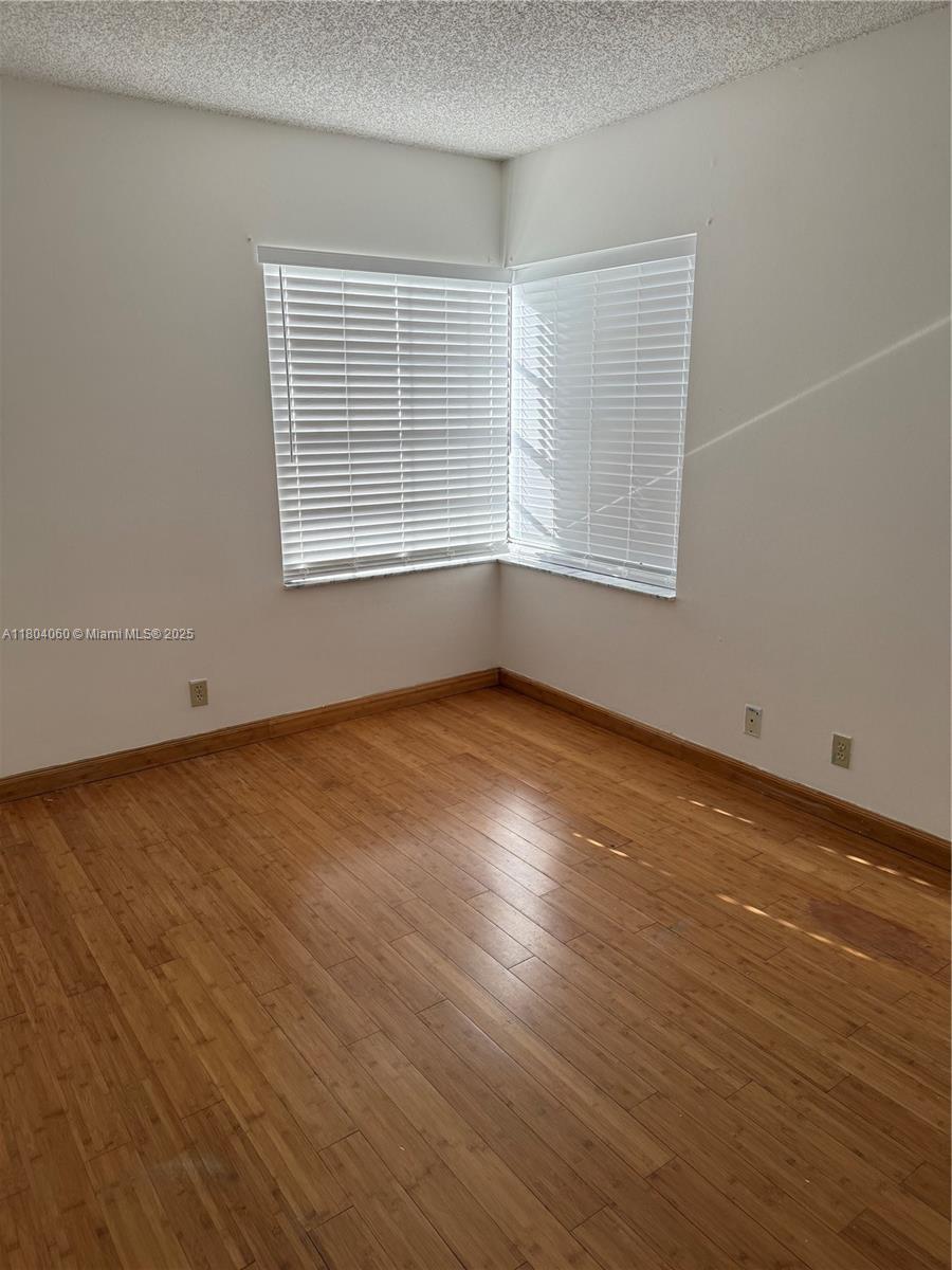 10631 Northwest 14th Street, Unit 229 Plantation, FL 33322 - Photo 9 of 12 wooden floor in an empty room with a window