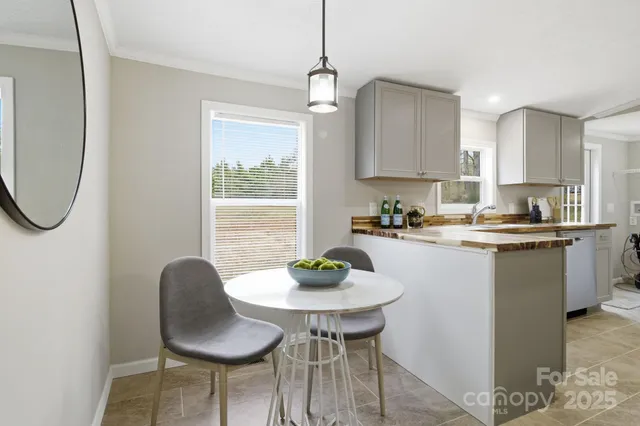 a kitchen with stainless steel appliances granite countertop a table chairs and a refrigerator
