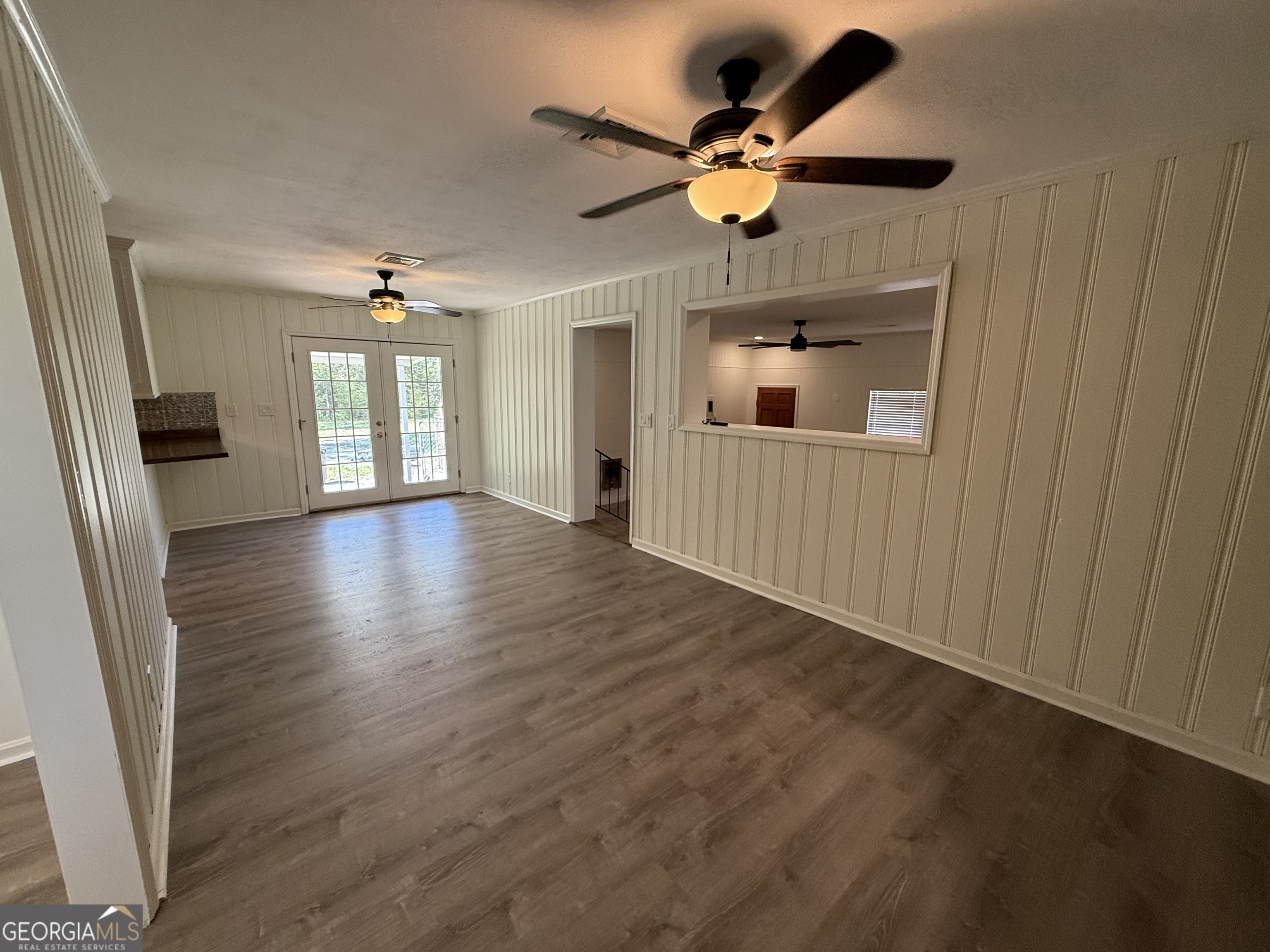 108 Plum Street Dublin, GA 31021 - Photo 28 of 33 an empty room with wooden floor chandelier fan and windows