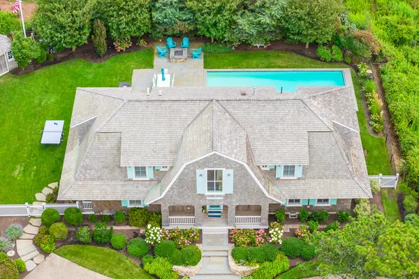 an aerial view of residential houses with outdoor space and trees