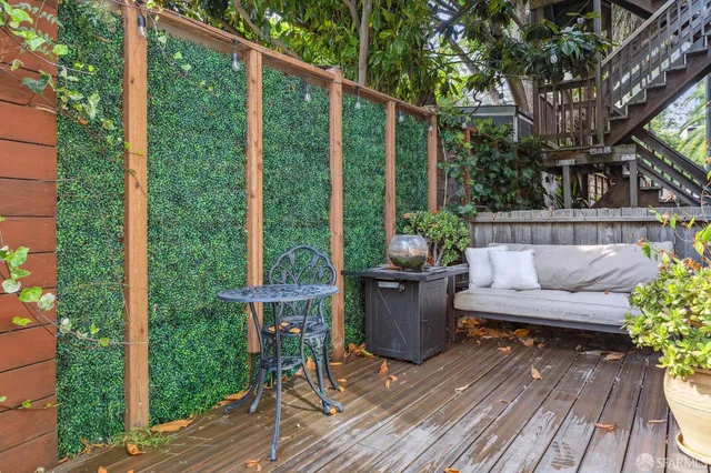 a view of balcony with chairs and wooden fence