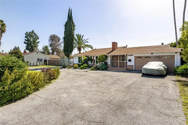 a front view of a house with a yard and potted plants