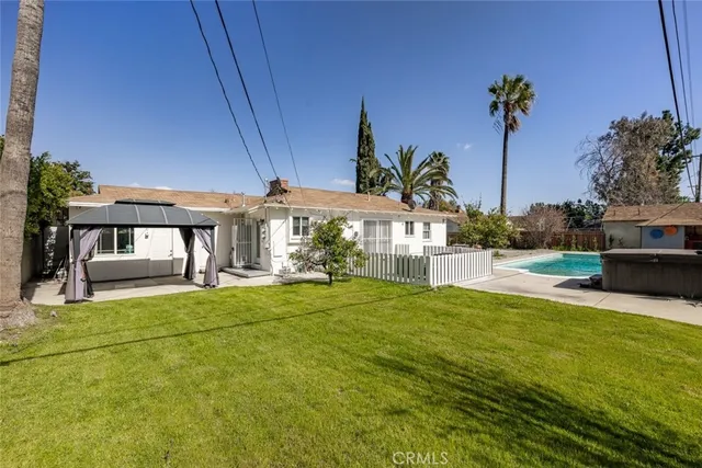 a view of a patio with couches chairs potted plants and wooden floor