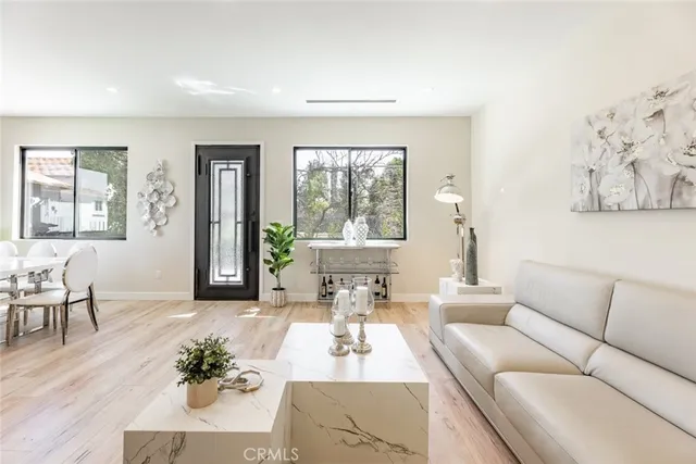 a dining room with furniture a large window and wooden floor
