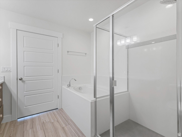 1278 South Grace Way Layton, UT 84041 - Photo 14 of 23 Contemporary bathroom featuring a built-in soaking tub with deck-mounted faucet, an enclosed glass shower, and wood-finish tile flooring