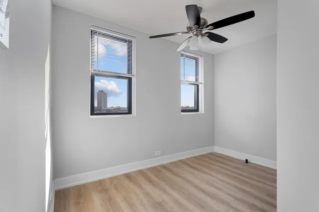 an empty room with windows and fan