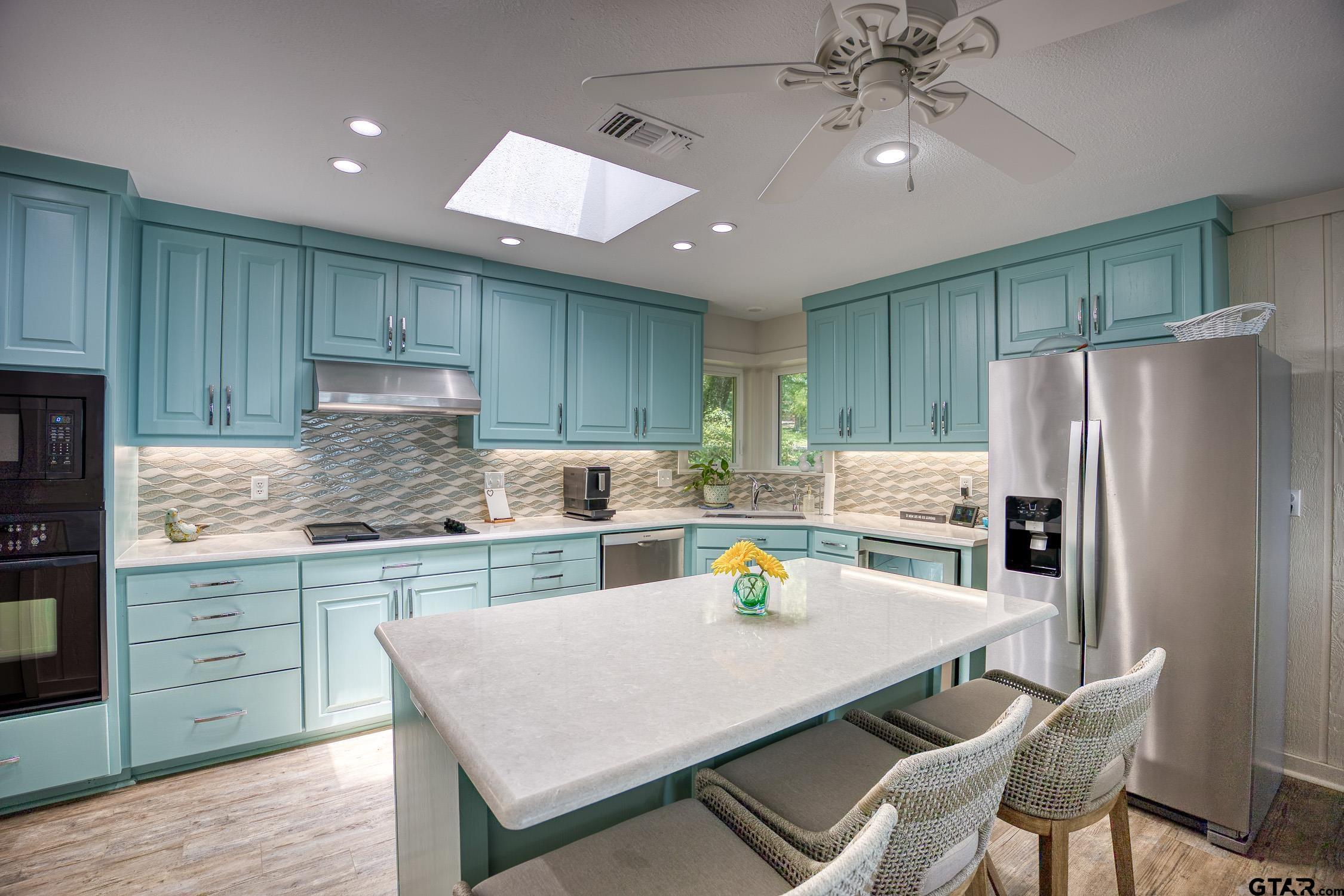 17553 Sleepy Hollow Way Flint, TX 75762 - Photo 15 of 41 a kitchen with a refrigerator a stove a sink dishwasher and white cabinets with wooden floor