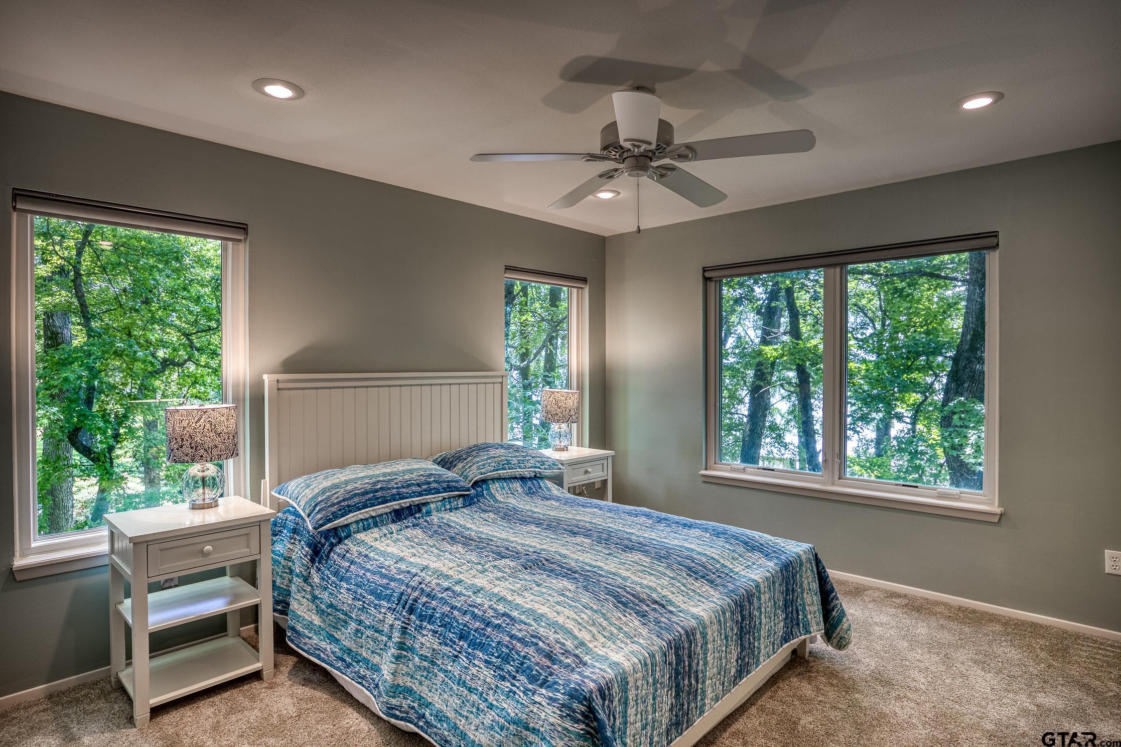 17553 Sleepy Hollow Way Flint, TX 75762 - Photo 24 of 41 a bedroom with a large bed and a chandelier