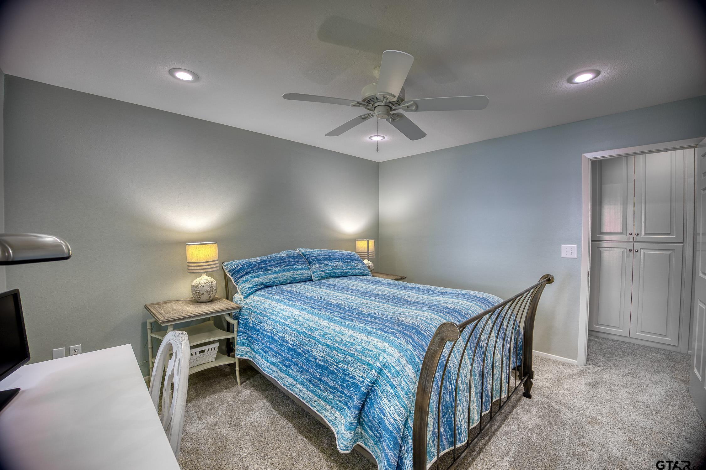 17553 Sleepy Hollow Way Flint, TX 75762 - Photo 28 of 41 a bedroom with a bed and a chandelier
