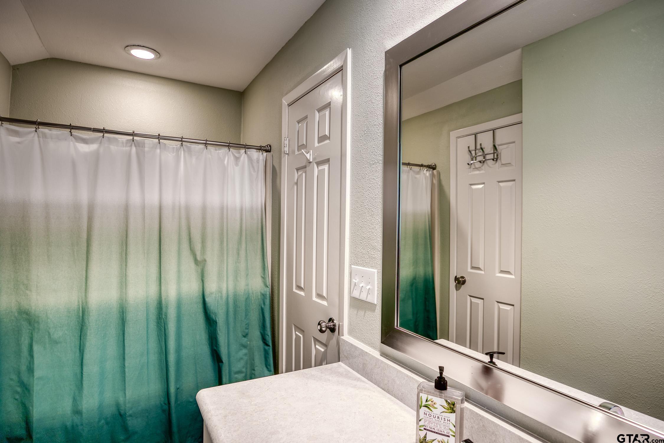 17553 Sleepy Hollow Way Flint, TX 75762 - Photo 29 of 41 a bathroom with a mirror a sink and a shower