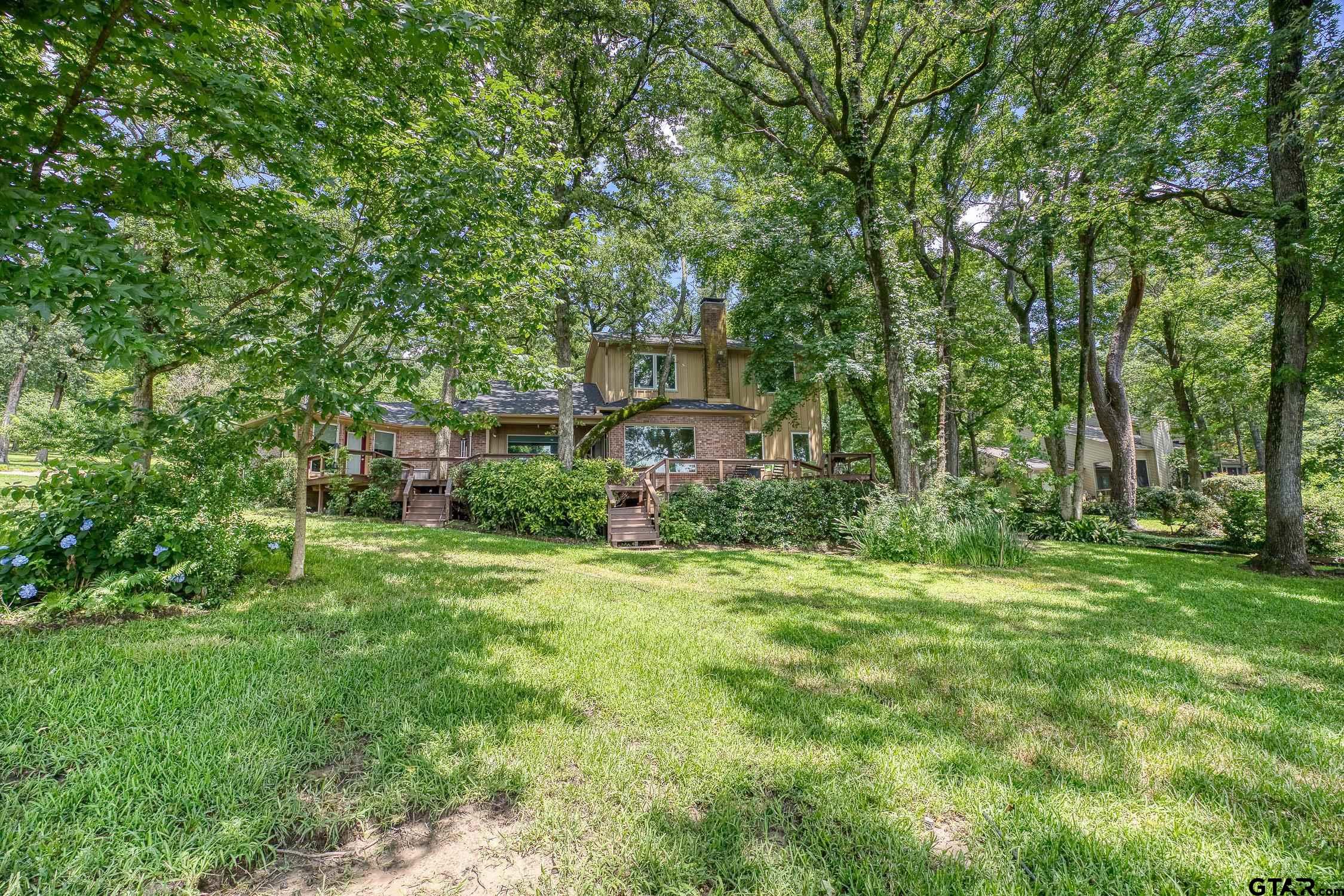17553 Sleepy Hollow Way Flint, TX 75762 - Photo 37 of 41 a backyard of a house with plants and large trees