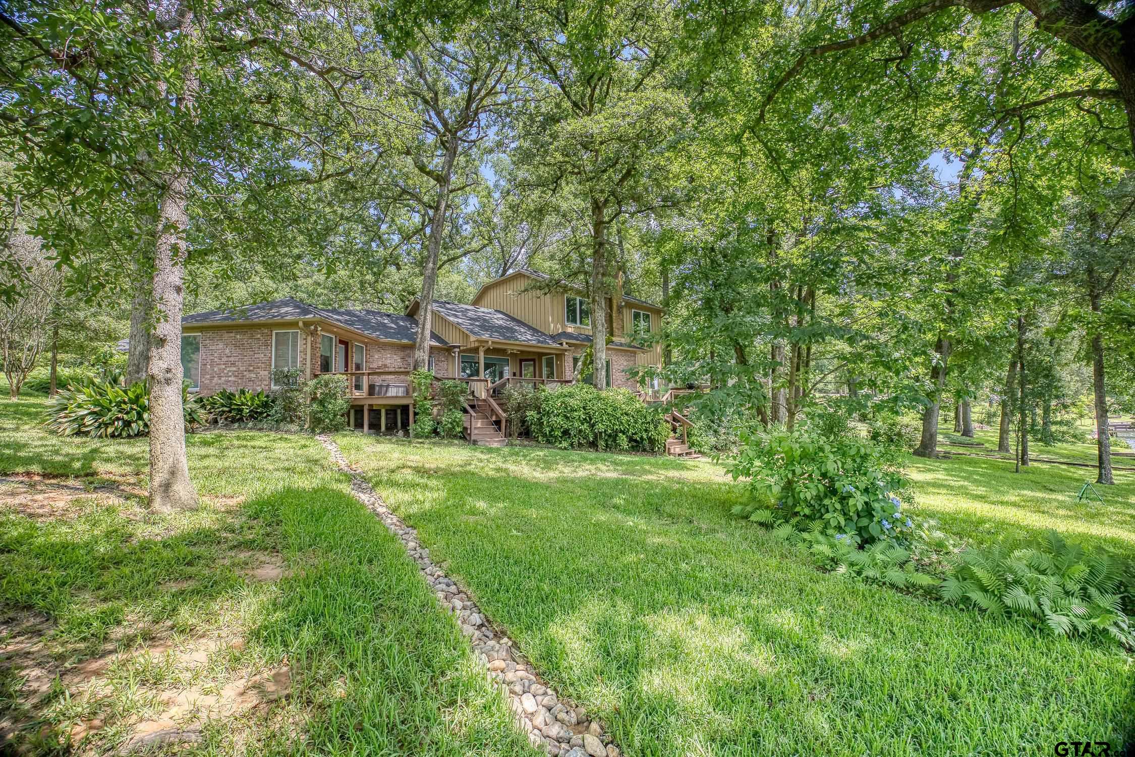 17553 Sleepy Hollow Way Flint, TX 75762 - Photo 38 of 41 a backyard of a house with plants and large trees