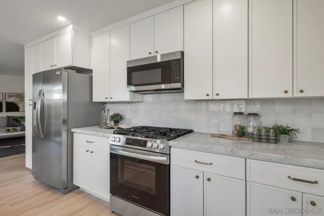 a kitchen with stainless steel appliances granite countertop a stove a microwave and a refrigerator