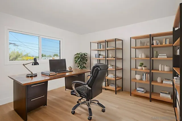a view of a workspace with furniture and a window