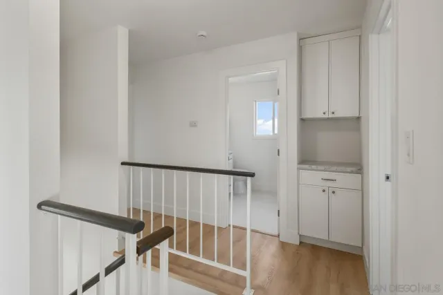 a view of a hallway with wooden floor and staircase