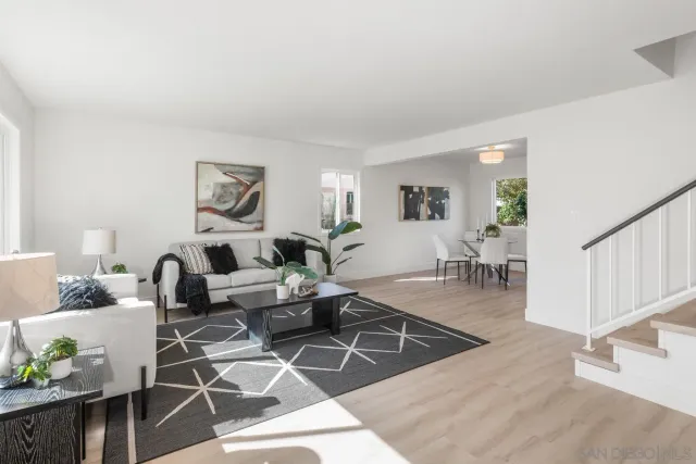a living room with furniture a wooden floor and next to a window