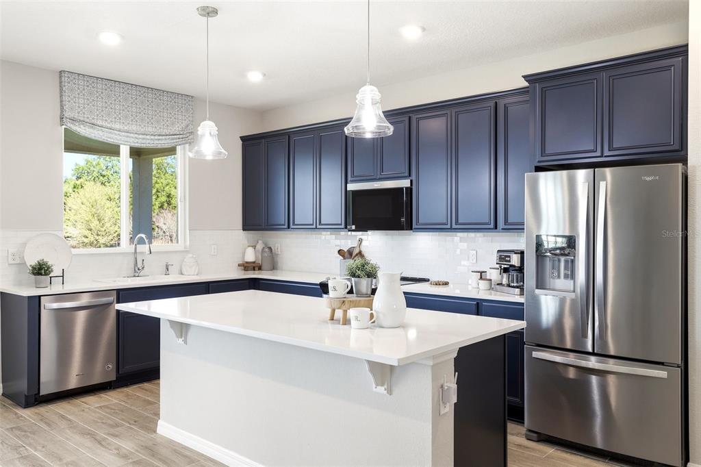740 Rioja Drive Minneola, FL 34715 - Photo 11 of 33 a kitchen with wooden cabinets and stainless steel appliances