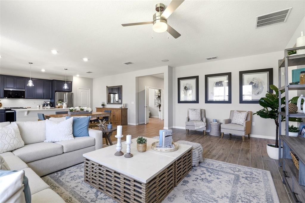 740 Rioja Drive Minneola, FL 34715 - Photo 19 of 33 a living room with furniture kitchen view and a wooden floor