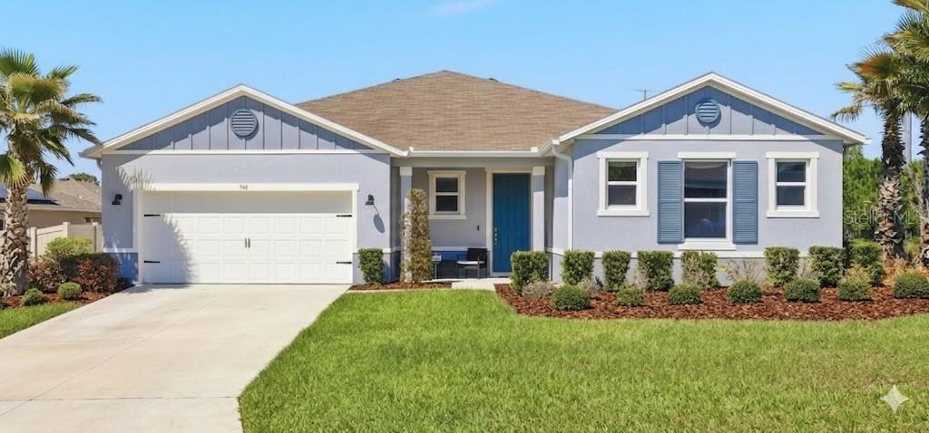 740 Rioja Drive Minneola, FL 34715 - Photo 2 of 33 a front view of a house with a yard and garage