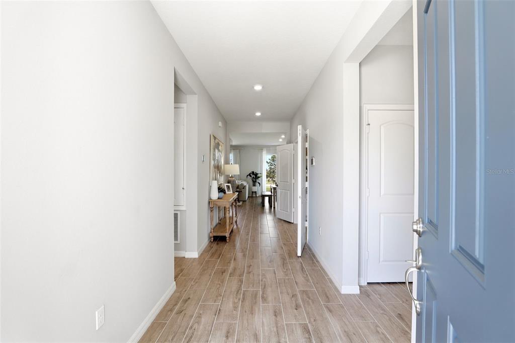 740 Rioja Drive Minneola, FL 34715 - Photo 4 of 33 a view of a hallway with wooden floor and a bathroom