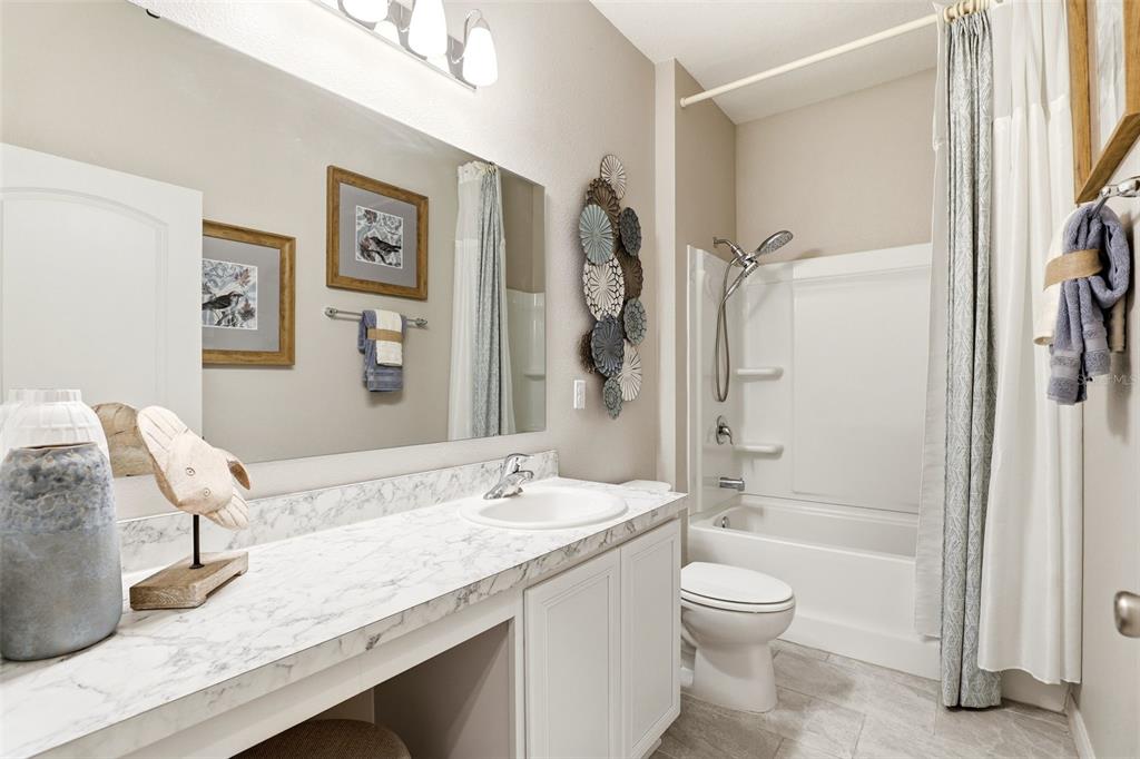 740 Rioja Drive Minneola, FL 34715 - Photo 6 of 33 a bathroom with a granite countertop sink a toilet and shower