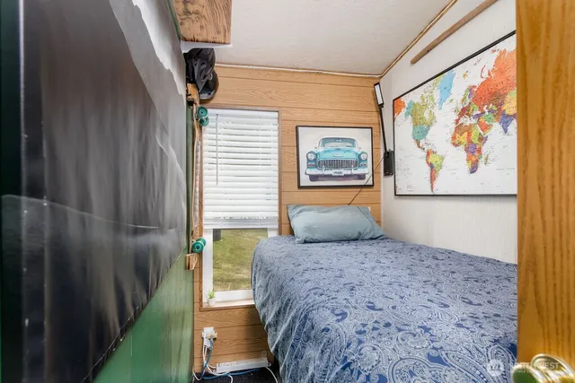 a bedroom with a bed and a painting on the wall