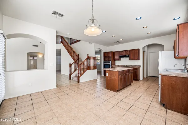 a view of kitchen with stainless steel appliances kitchen island granite countertop a stove a sink a refrigerator cabinets and living room view