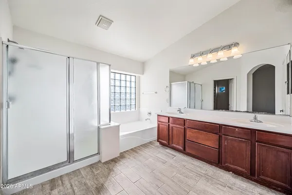 a spacious bathroom with a granite countertop sink mirror and a bathtub