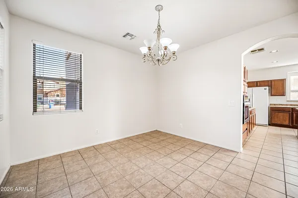 a view of a livingroom with a chandelier fan and windows
