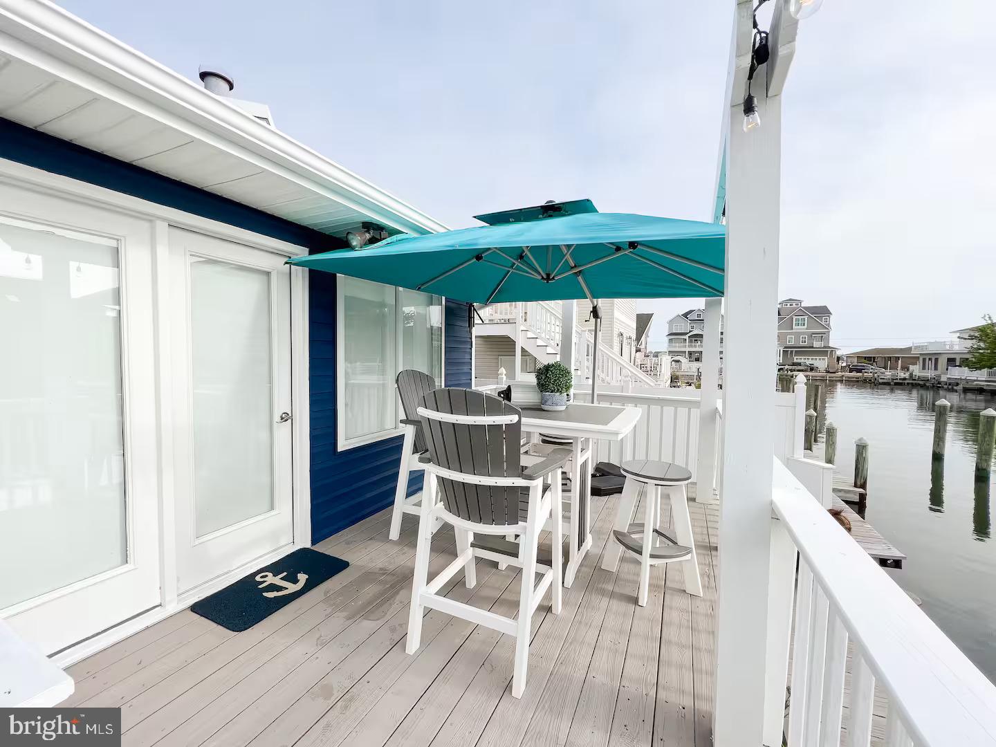 10609 Pine Needle Road Ocean City, MD 21842 - Photo 12 of 26 a view of a patio with table and chairs a barbeque with wooden floor and fence