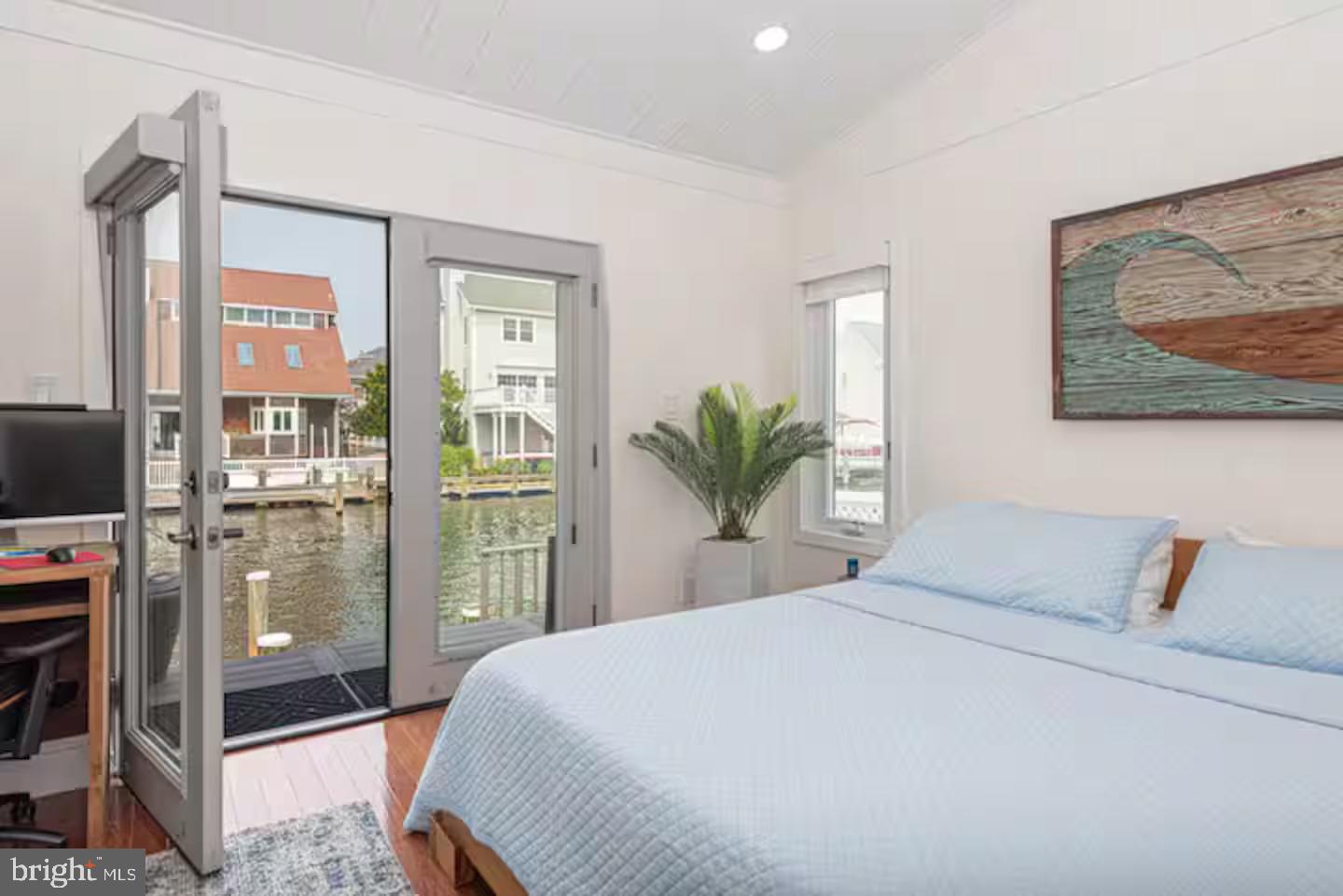 10609 Pine Needle Road Ocean City, MD 21842 - Photo 22 of 26 a bedroom with a large bed and a painting on the wall