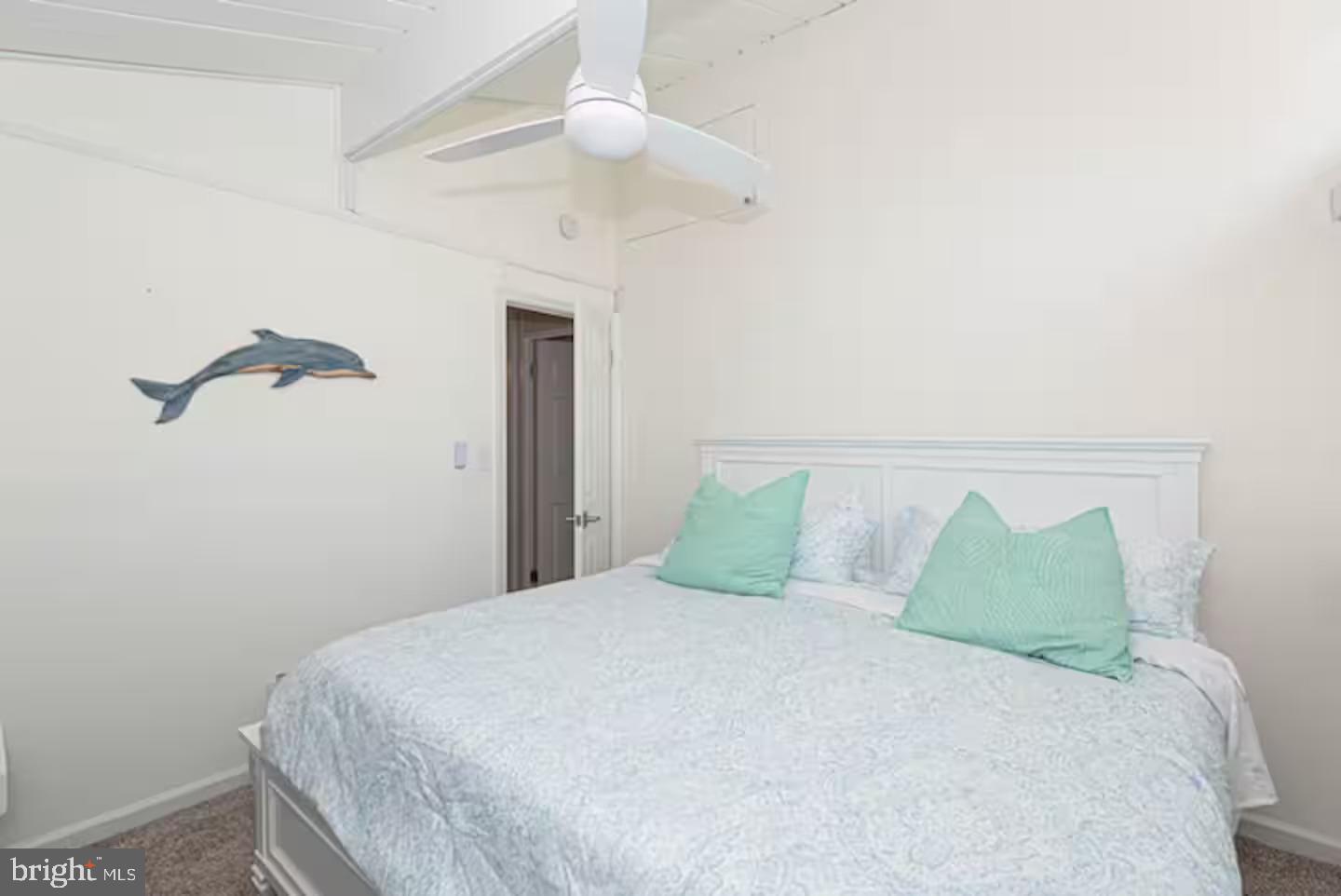 10609 Pine Needle Road Ocean City, MD 21842 - Photo 23 of 26 a large bed sitting in a bedroom next to a lamp