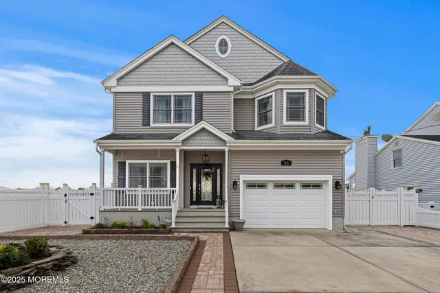 a view of a white house with large windows and a yard