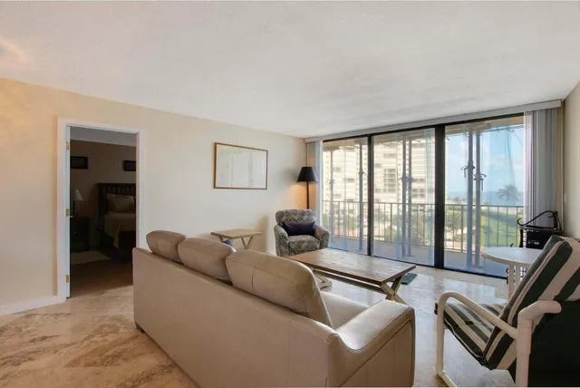a living room with furniture and large windows